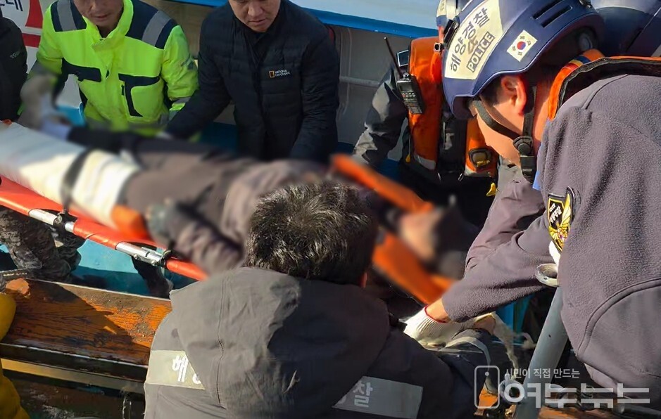 ▲ 여수해경이 연도 인근 갯바위에서 추락 부상을 입은 A씨에게 응급처치를 실시한 뒤 경비함정으로 옮기며 이송 작업을 진행하고 있는 모습.